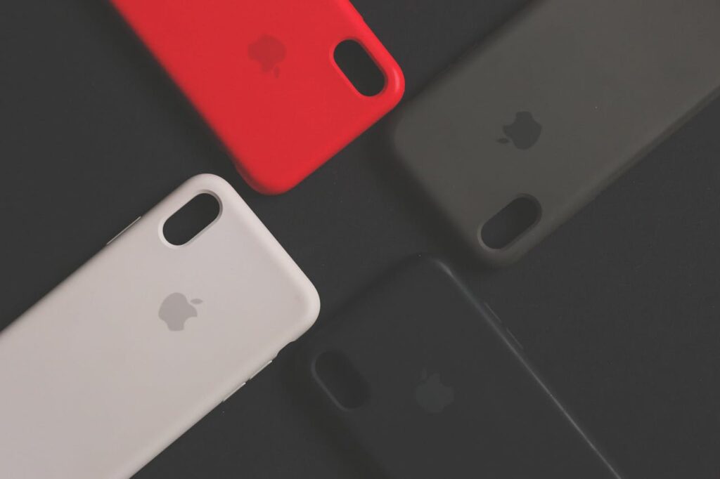 Four colorful smartphone cases on a dark surface, showcasing variety and design.