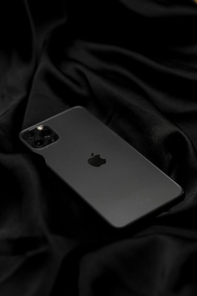 Stylish black smartphone set against smooth, luxurious black fabric. Perfect for showcasing technology and elegance.