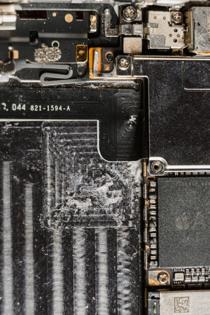 Detailed close-up of a dusty mobile phone circuit board showcasing various electronic components.